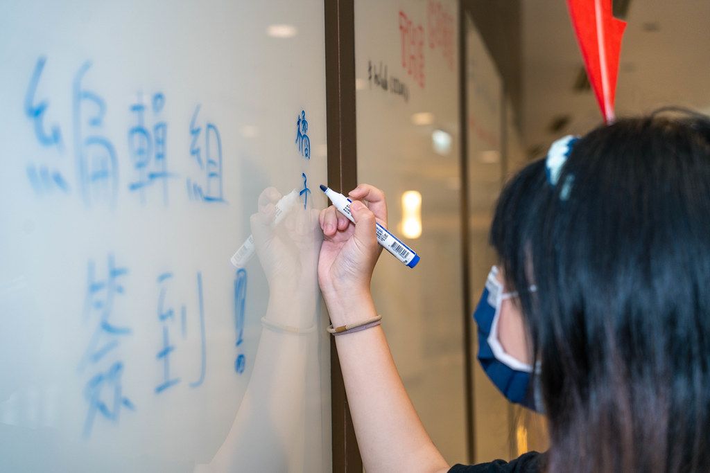 SITCON 工作人員在玻璃白板上書寫「編輯組」